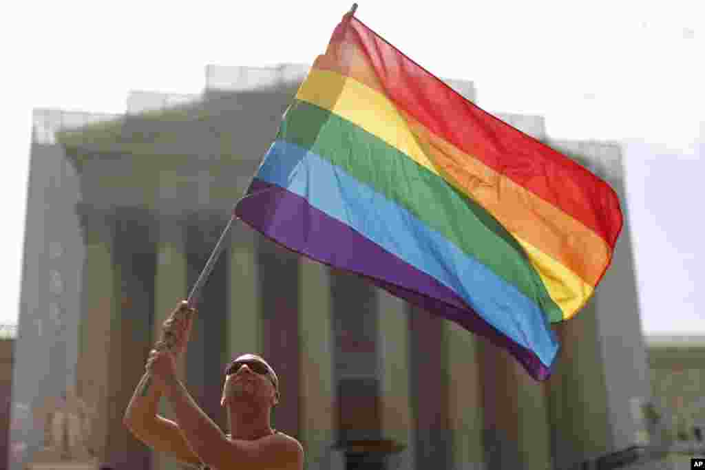 Vin Testa from Washington, waves the rainbow flag in support of gay marriage in front of the Supreme Court in Washington, June 24, 2013.