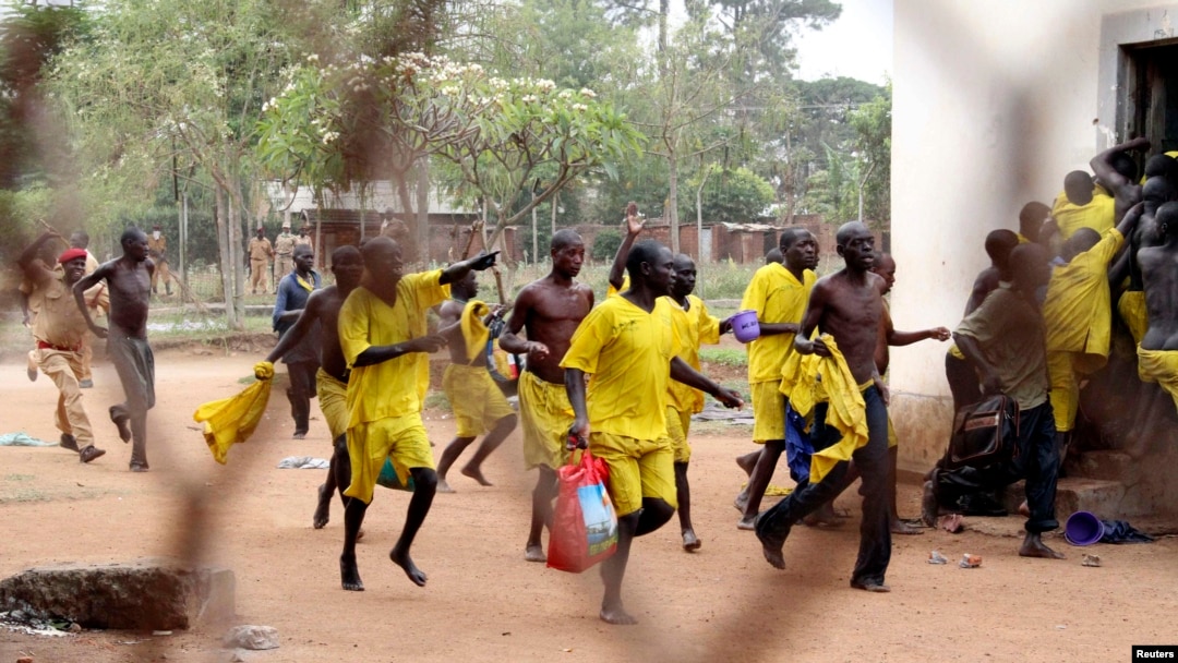 FILE - Prisoners runs towards their ward after their prison riot was quelled at the Lira Central Prison in Northern Uganda, Feb. 13, 2013. 