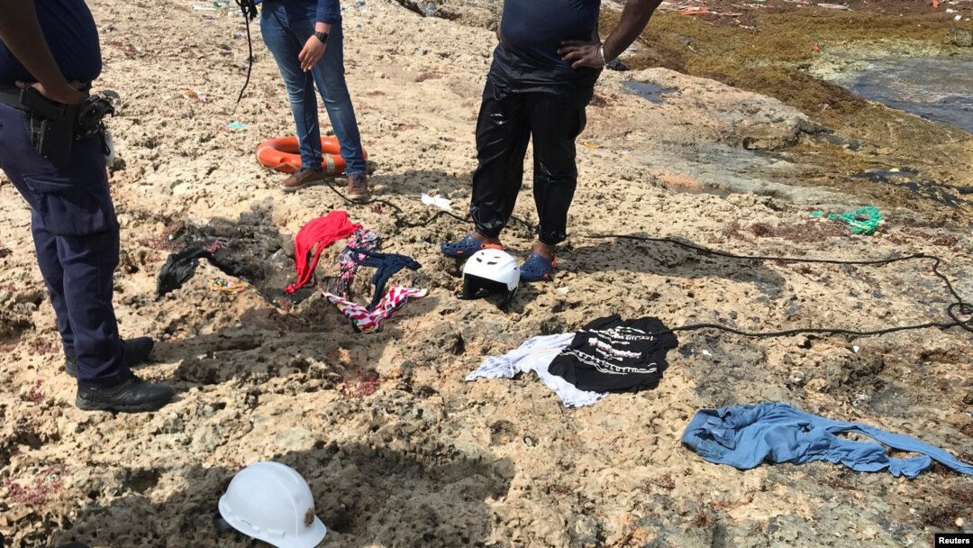 Policías de Curazao observan restos de ropa recuperados en una playa de la isla donde fueron encontrados los restos de cuatro venezolanos que perecieron en un naufragio el martes 9 de enero de 2018. Willemstad, Curazao, enero 11 de 2018.