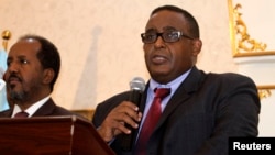 Somalia Prime Minister Omar Abdirashid Ali Sharmarke, right, flanked by Somalia's President Hassan Sheikh Mohamud, addresses delegates in the capital Mogadishu, Dec. 17, 2014. 