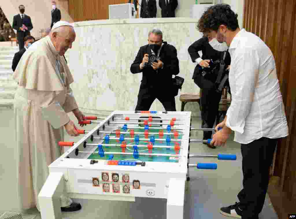 This handout phot released by the Vatican press office, Vatican Media shows Pope Francis playing football table against Natale Tonini of the Tuscany table football amateur association at The Vatican. 